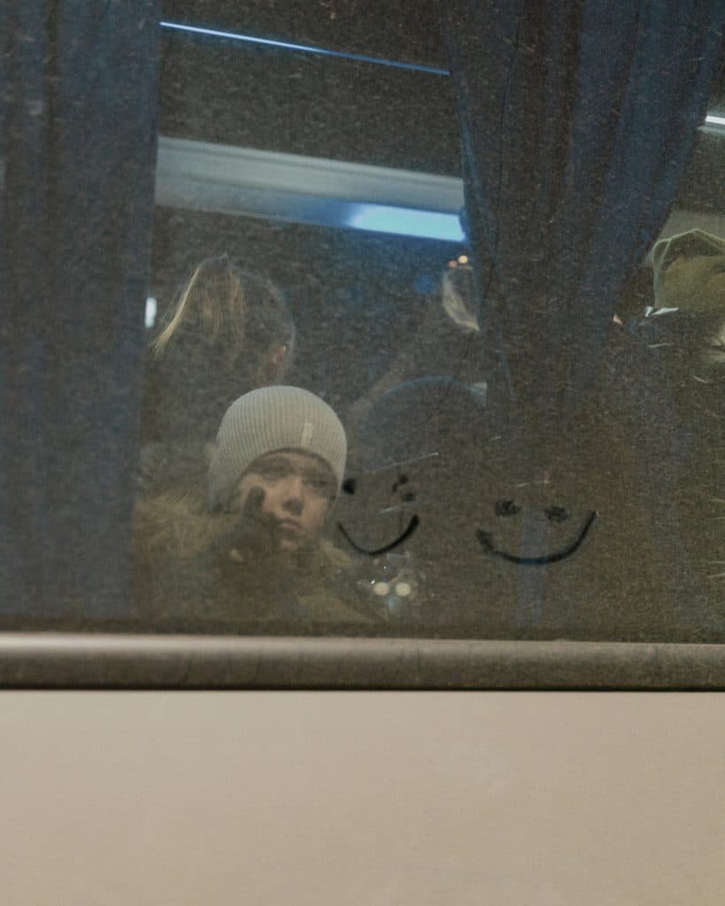 Un enfant dessine sur la fenêtre d'un bus près du point de transfert de Medyka, en Pologne. 2 mars 2022 © Ismail Ferdous / VU’ pour Blind