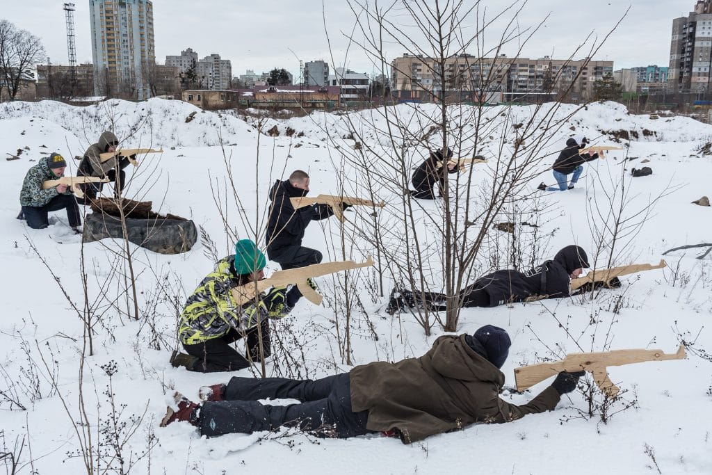 Des participants à l'entraînement de défense civile, organisé par une organisation politique d'extrême droite, National Corps, sur le terrain d'une usine de machines lourdes abandonnée dans la banlieue ouest de Kiev, s'entraînent avec une arme de fortune en bois à Kiev, en Ukraine, le 6 février 2022 © Oksana Parafeniuk.