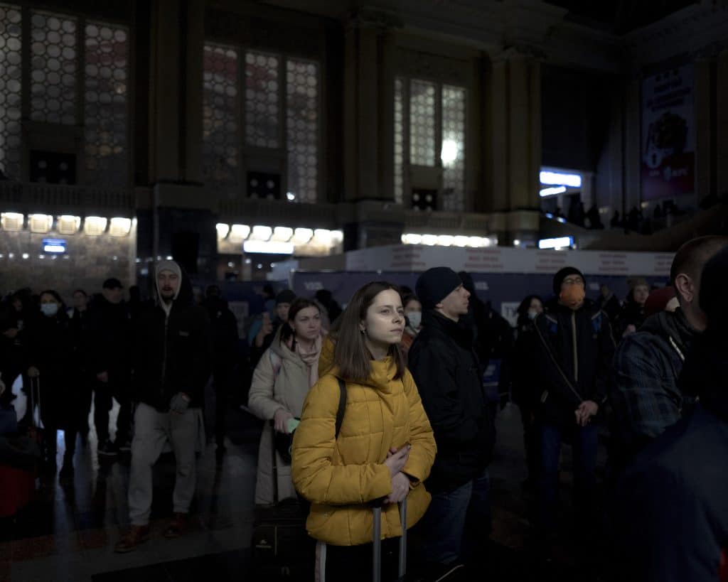 A young Ukrainian girl looks at the departure sign at the Kyiv train station on February 26, 2022. © Rafael Yaghobzadeh