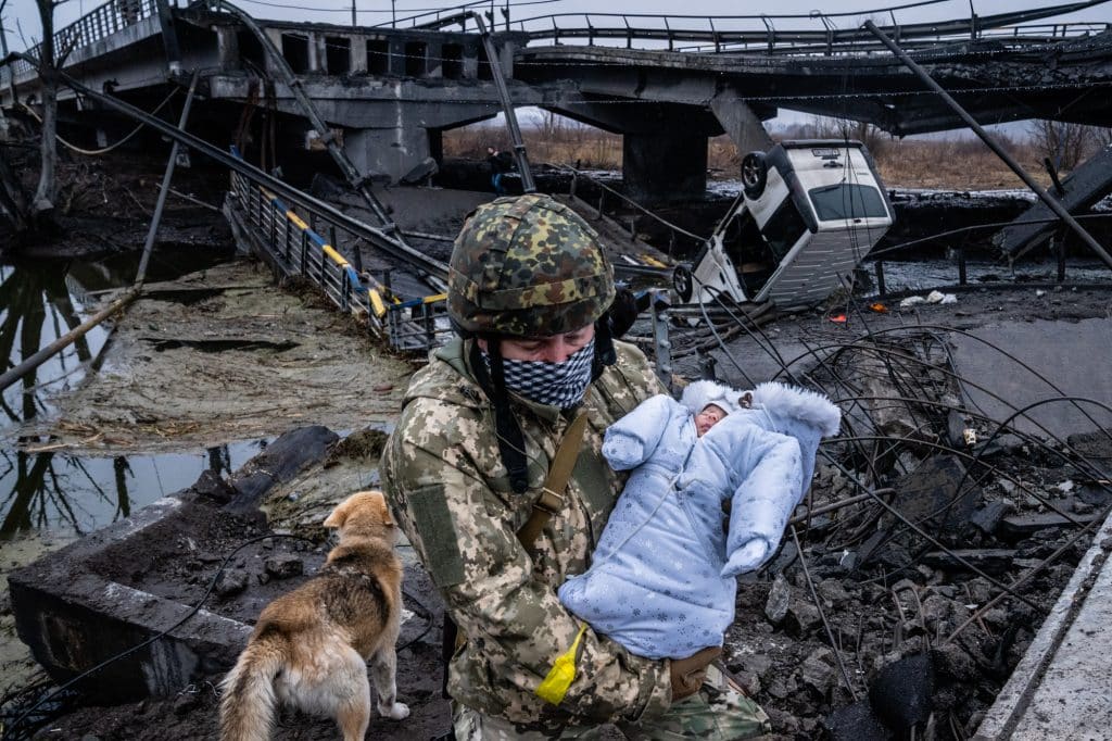 A family flees across a bridge destroyed in a Russian missile attack in the outskirts of Kyiv, Ukraine, Thursday, March 3. 2022 © Timothy Fadek / Redux