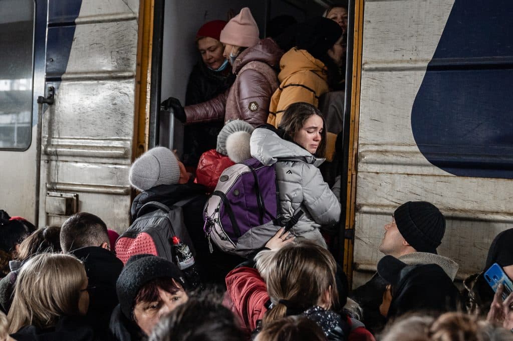 People crowd on the platform as they try to get on a train to Lviv at the main train station in Kyiv, Ukraine, Friday, March 4. 2022. Ukrainian men have to stay to fight in the war while women and children are leaving the country to seek refuge in a neighboring country. © Timothy Fadek / Redux