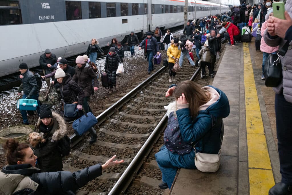 Des Ukrainiens marchent sur des rails pendant l'évacuation vers l'Ukraine occidentale, à la gare de Kiev, le 1er mars 2022 © Oleksandr Chekmenov