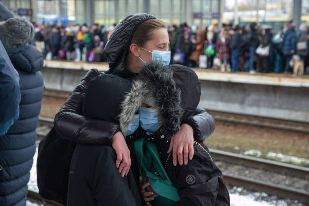 Allasha Pullenko, une Ukrainienne, tient ses deux enfants pendant son évacuation vers l'ouest de l'Ukraine, à la gare de Kiev. Kiev, le 1er mars 2022 © Oleksandr Chekmenov