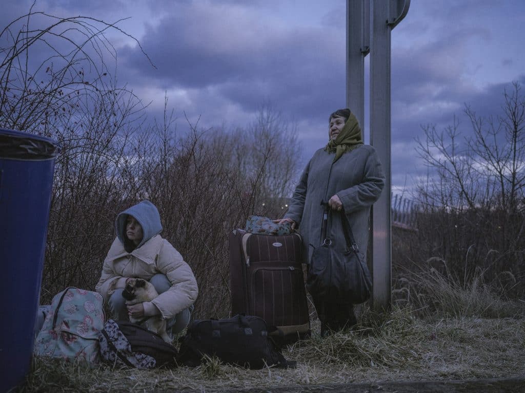 À la frontière entre la Slovaquie et l'Ukraine, une jeune femme, Viktoria, avec sa grand-mère, Oksana, et son chien. 8 mars 2022 © Ismail Ferdous / Agence VU' pour Blind