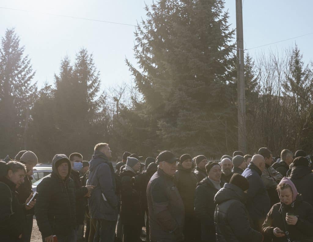 Des hommes attendent devant le bureau d'enrôlement militaire à Uzhhorod, en Ukraine. © Ismail Ferdous / VU' pour Blind