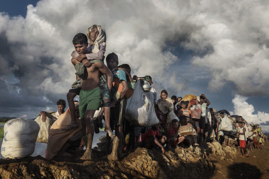 Palong Khali, Bangladesh. Thousands of exhausted Rohingya refugees fleeing from Myanmar walk along a muddy rice field after crossing the border in Palang Khali, Cox's Bazar, Bangladesh. Well over 755,000 Rohingya refugees have fled into Bangladesh since late August during the outbreak of violence in Rakhine state causing a humanitarian crisis in the region with continued challenges for aid agencies A policeman shines a flashlight on a man suspected of overdosing as drug addicts are seen smoking heroin and methamphetamine in an area where hundreds of users shelter live in squalid conditions at Pul-e-Sukhta, under a bridge in western Kabul © Paula Bronstein