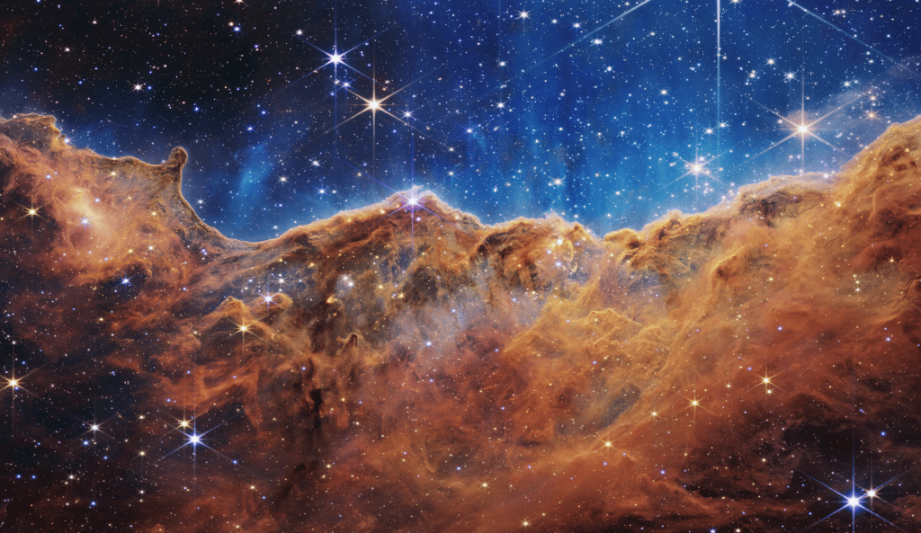 Star-forming region in the Carina Nebula. What looks much like craggy mountains on a moonlit evening is actually the edge of a nearby, young, star-forming region NGC 3324 in the Carina Nebula. Captured in infrared light by the Near-Infrared Camera (NIRCam) on NASA’s James Webb Space Telescope, this image reveals previously obscured areas of star birth. © NASA