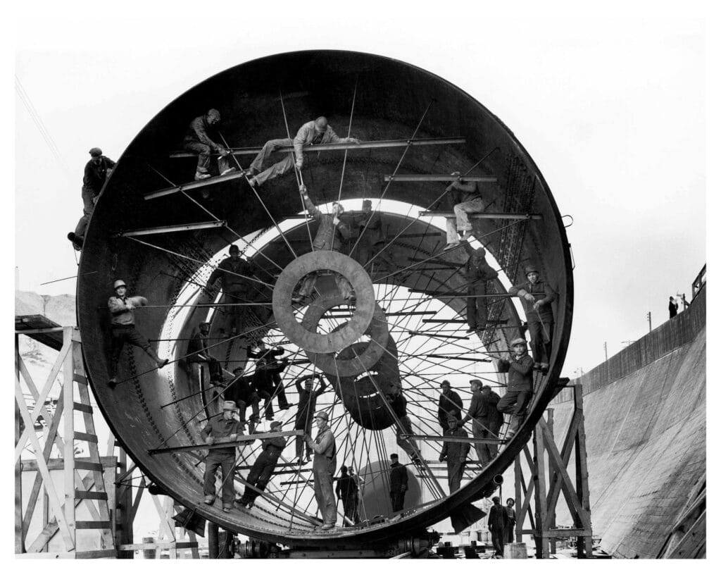 Ouvriers travaillant sur des tuyaux géants utilisés pour détourner une section du fleuve Missouri lors de la construction du barrage de Fort Peck. Fort Peck, Montana, États-Unis d'Amérique, 1936. Margaret Bourke-White ©The LIFE Picture Collection