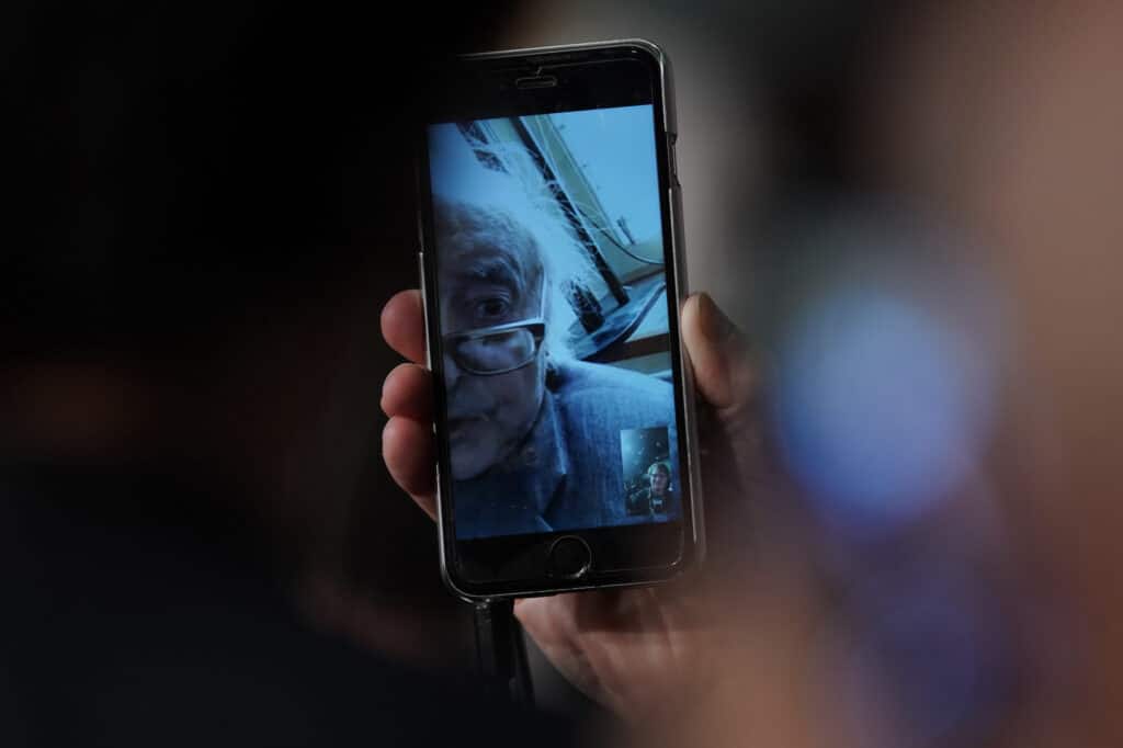 Jean-Luc Godard addresses a press conference through a mobile phone, from his home in Switzerland, in 2018 for his film "Image Book" at the 71st edition of the Cannes Film Festival in Cannes, southern France. © Laurent EMMANUEL / AFP