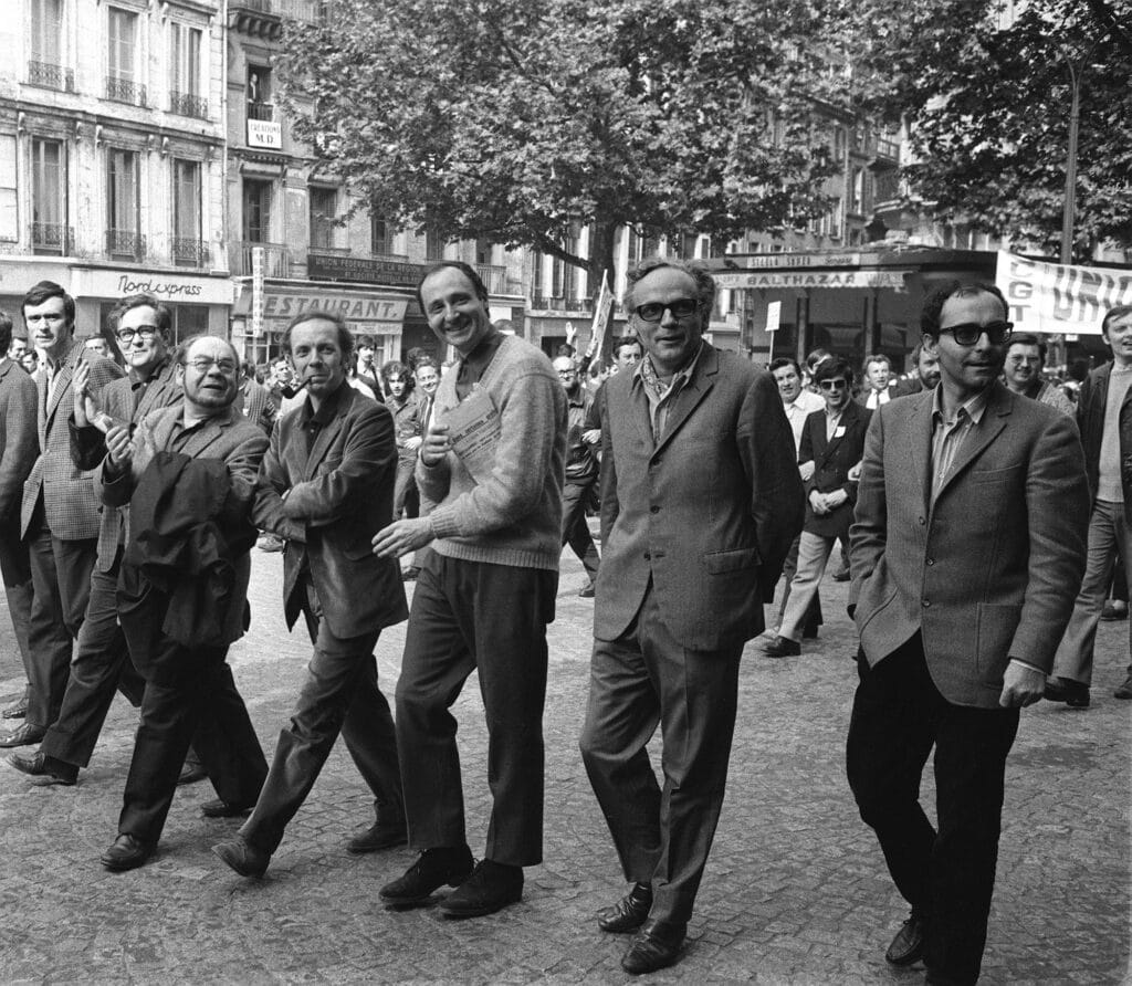 Jean-Luc Godard (d), le poète Alain Jouffroy (2e g) et le poète communiste Eugène Guillevic (3e g) défilent, avec des membres du Syndicat des acteurs, à Paris le 29 mai 1968, pendant la grève générale de mai-juin 1968. © AFP