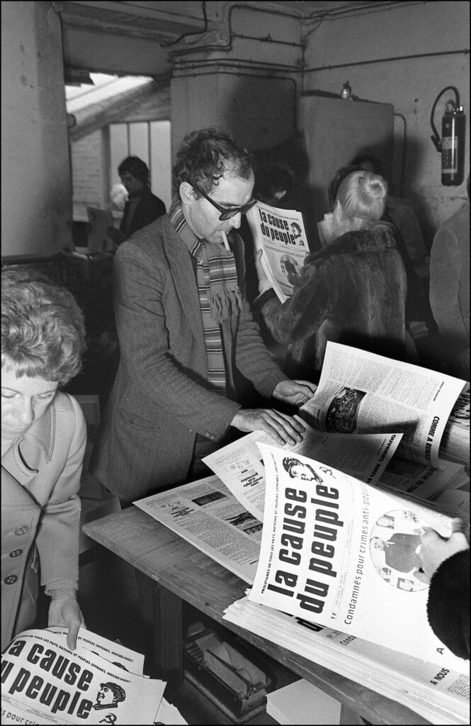 Jean-Luc Godard (C) consulte le dernier numéro de La Cause du Peuple dans l'imprimerie du journal maoïste le 6 novembre 1970 à Paris, avant qu'il ne soit vendu à la pièce dans la rue. © AFP