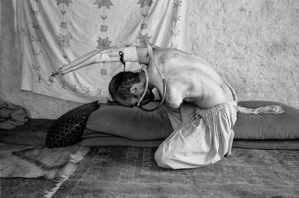 Ghafor, 35, mine victim without arms, father of seven, uses his mouth to put on his prosthesis. Kabul, Afghanistan. July, 2003 © Jane Evelyn Atwood