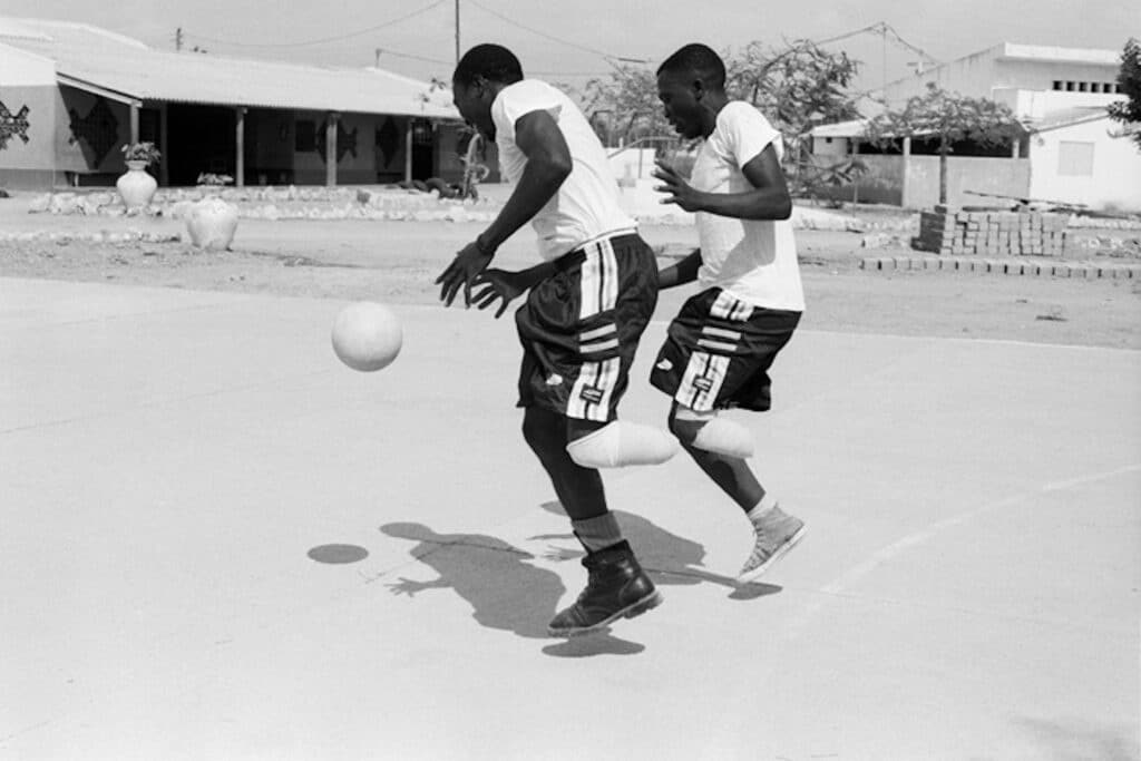 Deux victimes de mines renforcent leur seule jambe en jouant au basket sans leur prothèses. Centre Orthopédique, Benguela, Angola, 2002 © Jane Evelyn Atwood