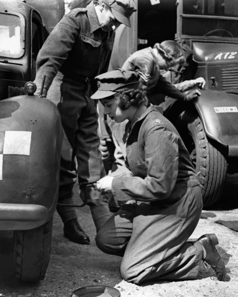 La princesse Elizabeth change la roue d'une voiture lors d'un entraînement dans un centre de formation de l'A.T.S. (Auxiliary Territorial Service, la branche féminine de la British Army au cours de la Seconde Guerre mondiale), dans le sud de l'Angleterre, en 1945. Elle participera à l'effort de guerre en travaillant comme mécanicienne et conductrice d'ambulances. © CENTRAL PRESS / AFP