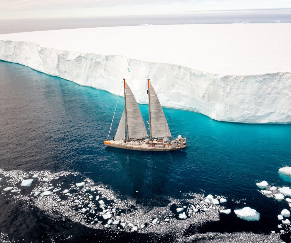 The Tara is a schooner and a scientific research vessel, seen here on the Weddell Sea taking water samples at the foot of an iceberg measuring one square kilometer, as part of a study of the impact of melting ice on the marine microbiome. © Maéva Bardy/The Tara Ocean Foundation, with the participation of Le Figaro Magazine