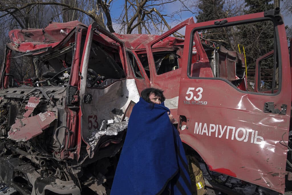 Une femme devant un camion de pompiers détruit par des tirs d’obus. Marioupol, Ukraine, 10 mars 2022 © Evgeniy Maloletka / Associated Press