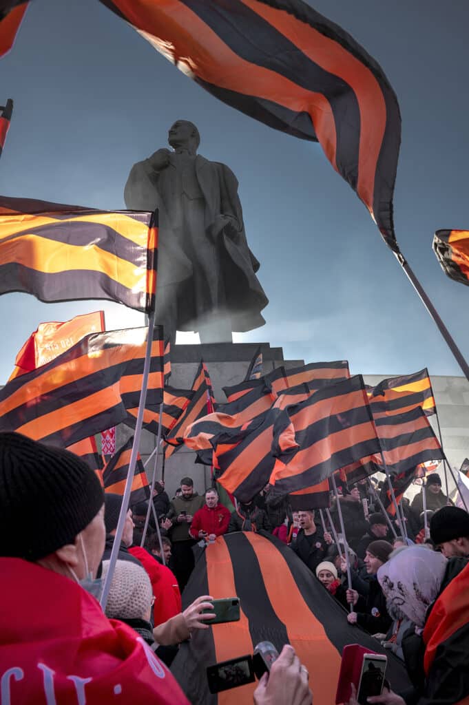 Des Russes portant des drapeaux et des rubans de Saint-Georges au pied de la statue de Lénine, près du stade Loujniki de Moscou où se tenait un rassemblement patriotique le 18 mars pour marquer le huitième anniversaire de la « réunification » de la Crimée et de la Russie. © Elena Chernyshova / Panos Pictures