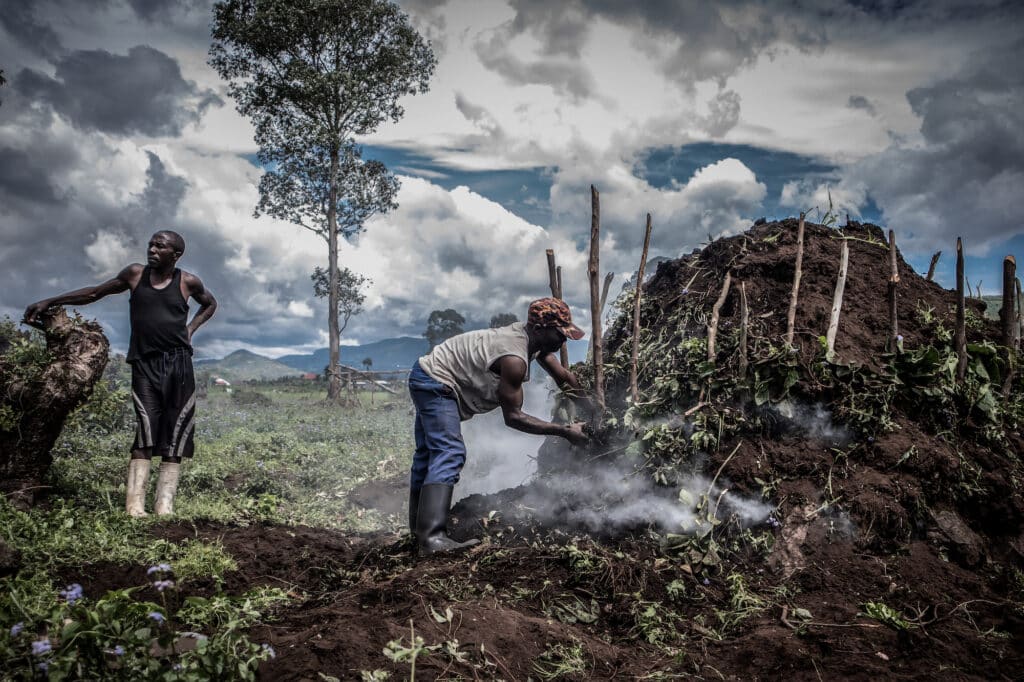 Villagers fuel a kiln to make charcoal on a swathe of deforested land on the edge of Virunga National Park just north of the eastern Congolese city of Goma. © Guerchom Ndebo / Fondation Carmignac.