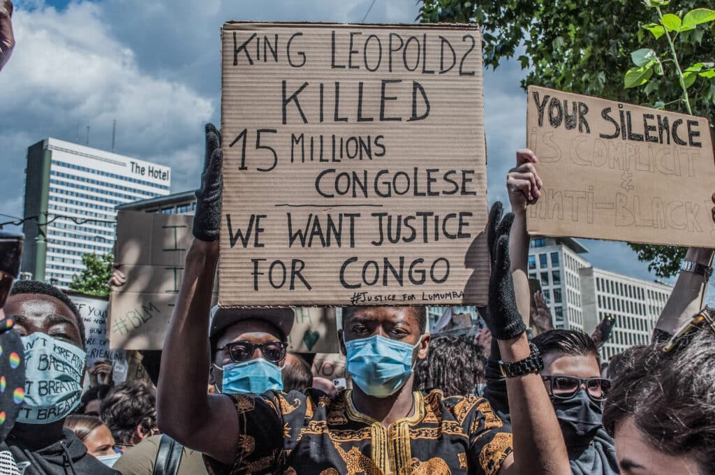 A protesters at a Black Lives Matter rally in Brussels this weekend carries a sign denouncing Belgium's imperial exploitation of what is now the Democratic Republic of Congo. As massive gatherings for racial justice gain momentum around the world, activists in Belgium are hoping the global movement may finally shift attitudes toward the colonial legacy of King Leopold II, the monarch whose tyrannical rule over the Congo Free State (now the Democratic Republic of Congo) is blamed for the deaths of between 10-15 million Congolese. © Pamela Tulizo / Fondation Carmignac