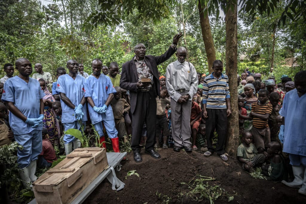 Des agents funéraires de la Croix-Rouge et des personnes en deuil assistent à l'enterrement d'une fillette de 11 mois, décédée dans la ville de Rutshuru, dans la province du Nord-Kivu, pendant l'épidémie d'Ebola, février 2020. © Finbarr O'Reilly