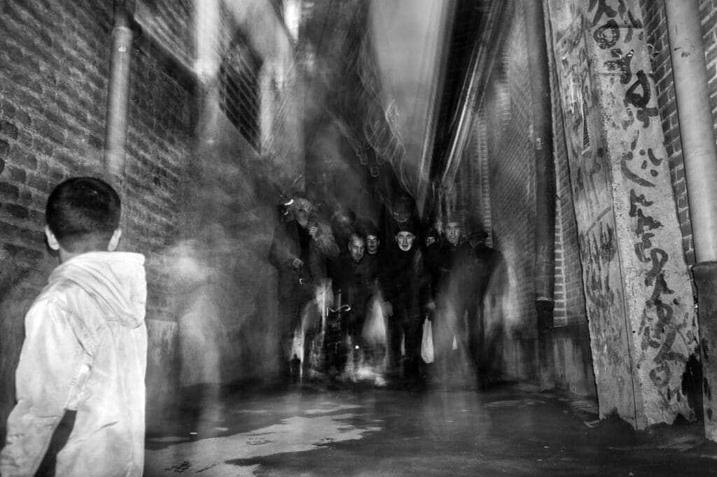 Un groupe de personnes en deuil traverse l'allée la nuit du jour de l'Achoura à Tabriz, en Iran, le 4 novembre 2014. En Iran, les rues appartiennent à l'idéologie dominante et les adeptes de cette idéologie ont massivement le droit de réaliser leurs propres cérémonies dans les rues. L'opposition, en revanche, n'a pas le droit de se réunir ou d'annoncer sa présence et ils sont sévèrement réprimés. © Farshid Tighehsaz