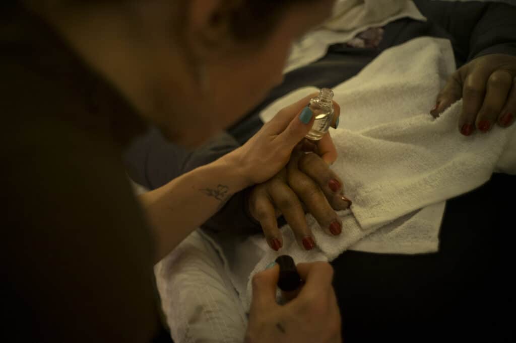 Nichole DeNunzio, intern, paints the nails of a decedent, at the Evergreen Funeral Home, and her colleagues have become known as "last responders." During the early stages of the pandemic in April, the funeral home handled 79 cases, compared to the normal average of 10 per month.The funeral home has been owned and operated by the Kwiatkowski family for four generations, with all faiths represented, including Coptic Christians, Hindu, and Catholic. Ms. DeNunzio said, "I am the last person to hug them." Jersey City, New Jersey, May 15, 2020 © Alan Chin