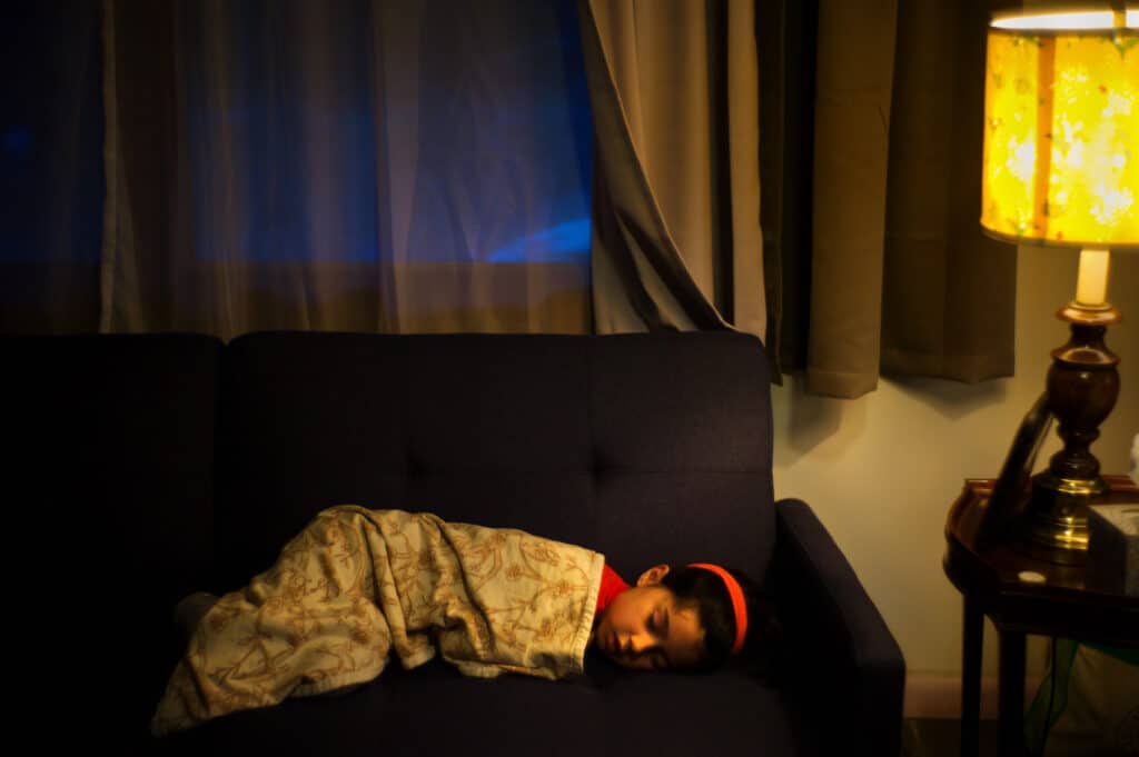 La fille du photographe, Hannah Derbes Chin, 6 ans, fait une sieste sur un canapé. Les écoles publiques de la ville de New York ont fermé le lundi 16 mars, en réponse à l'augmentation rapide des infections et des décès dus au Covid-19. Shandaken, New York, 26 mars 2020. © Alan Chin
