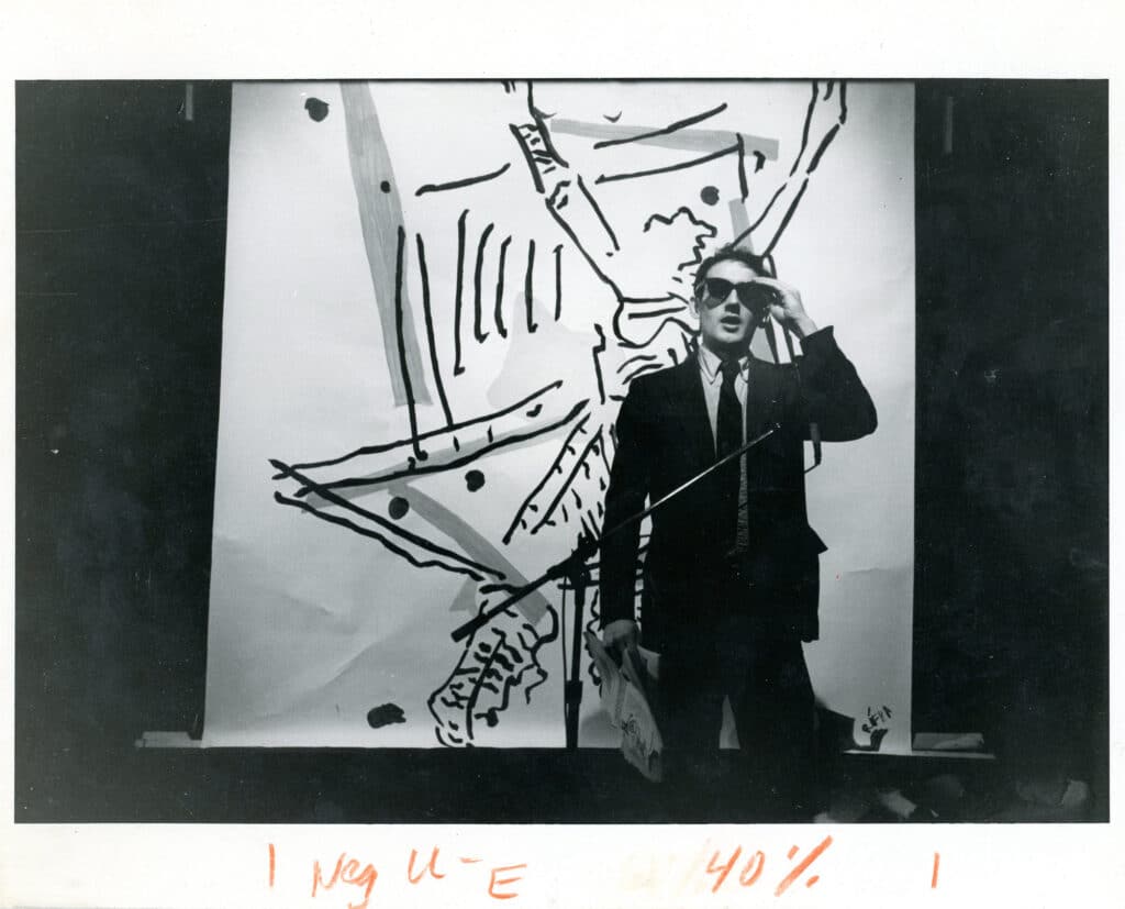 Peter Fend monologue in front of a Judy Rifka backdrop at ABC No Rio: The Island of Negative Utopia, The Kitchen, 1984. Photo by Teri Slotkin.
