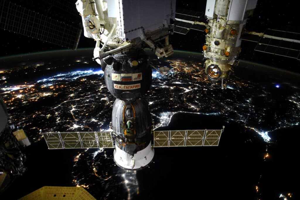 Night flight on the ISS - View on Cygnus solar panel, Soyuz, MLM © La Terre entre nos mains, Flammarion / ESA/NASA Thomas Pesquet