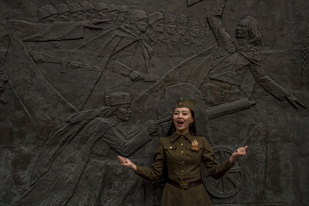 Une chanteuse de la chorale de l’Armée Kazakhstanaise lors de la réalisation d’un clip video, sous une fresque commémorant le courage de l’Armée Rouge pendant la seconde guerre mondiale. Le clip sera diffusé sur les réseaux sociaux le lendemain, le 9 mai, lors du jour de Victoire, jour choisi en Union Soviétique.
