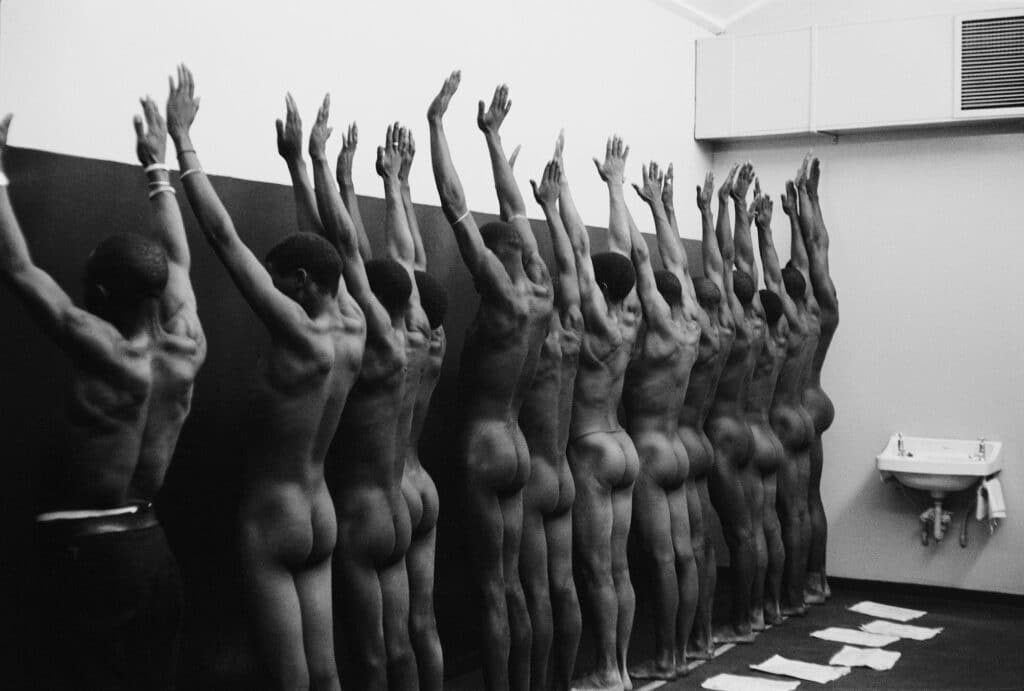 During group medical examination, the nude men are herded through a string of doctors’ offices. © Ernest Cole
