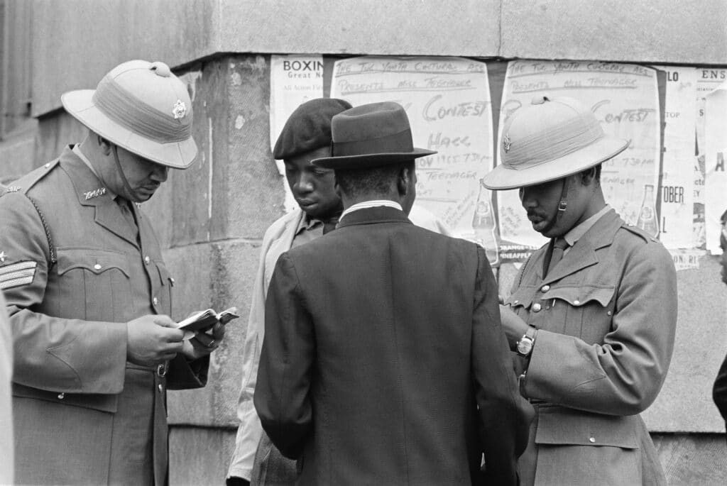 Police check passes for employers signature, proof that taxes are paid, and legality of presence in white area. © Ernest Cole
