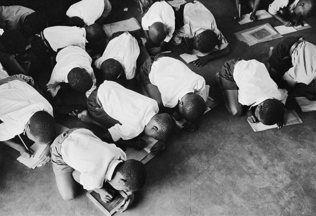 Students kneel on floor to write, South Africa, ca. 1960s. © Ernest Cole