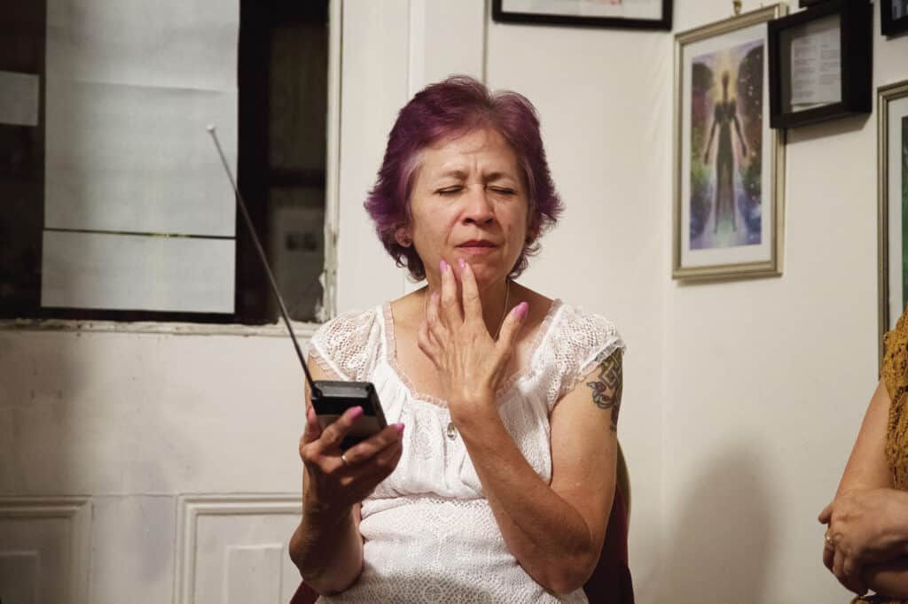 Naomi Barbar écoute les messages des esprits à partir d'une " boîte à fantômes ". Lily Dale, NY, 2015. © Shannon Taggart