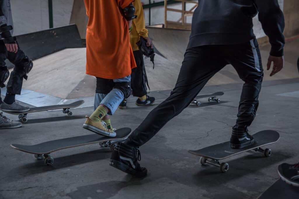 Close-up of skateboards and legs of young Ukrainian refugees at Gleis D Skate Halle. Hanover, Germany. April 27th, 2022. © Thomas Girondel