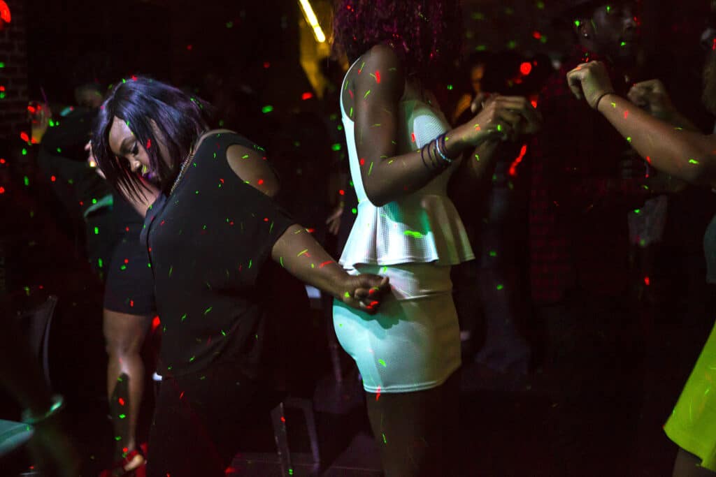 Women dance at the Blend party in Paris. Blend is a disco party for children of African immigrants in France. Unlike their parents who remained anchored in their community of origin, the children of the first generation meet between their various African origins by recognizing their mixed double cultures. Paris, Ile-de-France, 2015. © Carolina Arantes