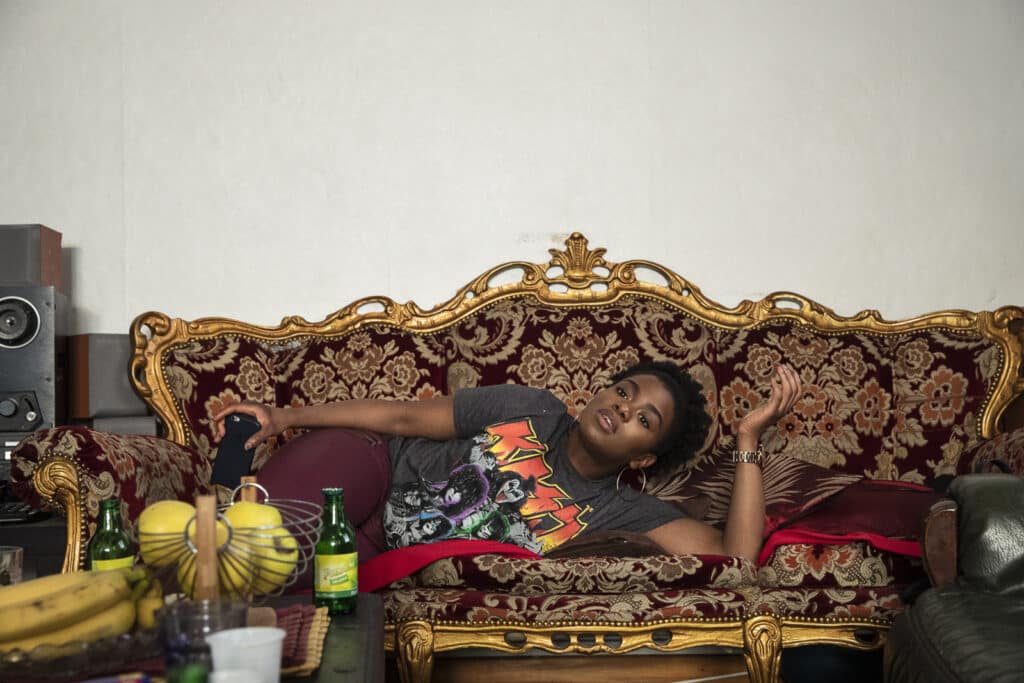 Kheira lies down after a lunch at her cousins' house. Despite her success, and to get around the difficulties of finding a job as a black woman in France, Kheira is starting a business related to Afro products. Many first generation women are doing the same in France. Bezons, 2018 © Carolina Arantes