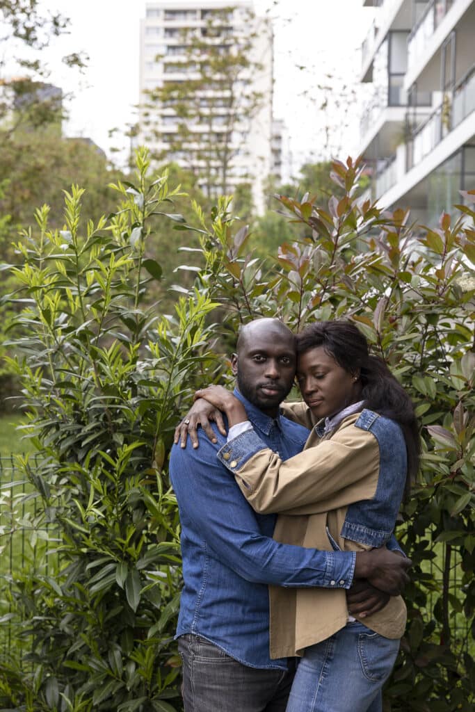 Hélène Djiba et son mari dans leur appartement du premier étage à Bagnolet, une ville située en Île-de-France, en banlieue de Paris. Après un premier mariage difficile, Hélène a trouvé ce qu'elle appelle un parfait compagnon : un homme qui la soutient dans sa liberté de pensée, dans son indépendance et dans sa façon d'apprendre à construire son identité de femme contemporaine. Bagnollet, 2022. © Carolina Arantes