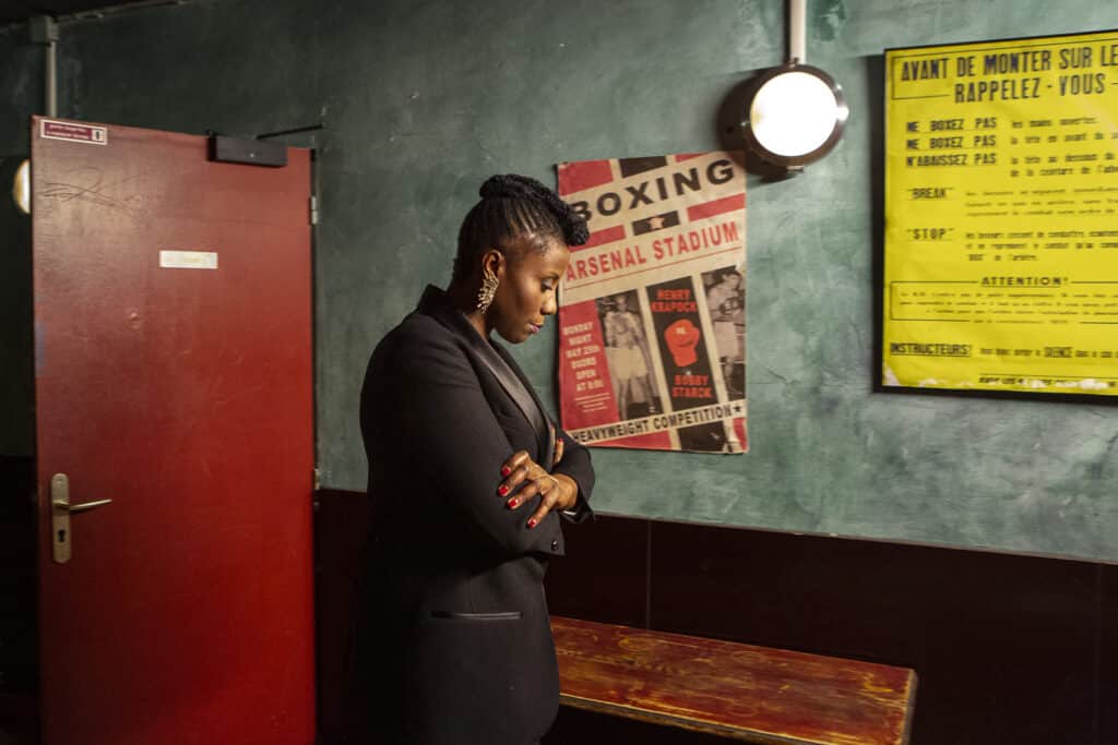 Aline Afanoukoé, présentatrice de télévision et de radio, dans les coulisses de l'enregistrement de son émission musicale, The Ring, à La Bellevilloise, pour la chaîne de télévision France Ô. Aline est l'une des premières femmes de la radio française à inclure la diversité musicale, africaine et mondiale, dans l'écoute quotidienne de la musique en France. Paris, Île-de-France, 2014. © Carolina Arantes