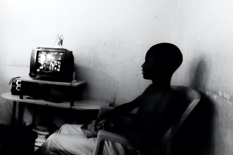 Fabien Ouedraogo, alias Papy, regarde la télévision jusqu'à tard dans la nuit. Dans cette maison, comme souvent au Burkina Faso, la télévision est une échappatoire. C’est aussi un outil utilisé par la néocolonisation. Burkina Faso, Karpala, décembre 2021.