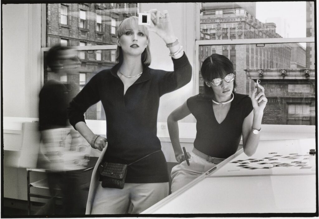 Deux mannequins dans un bureau regardant des négatifs, 1976, Vogue, © Condé Nast / Duane Michals