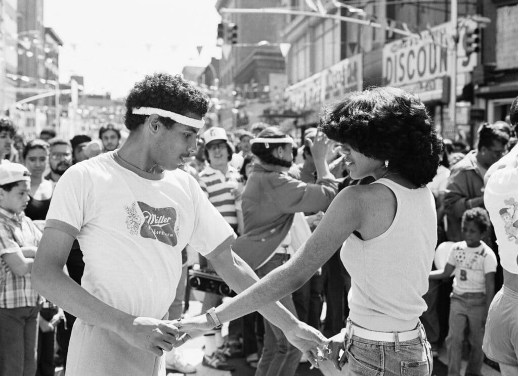 Roller skating dancers at street festival, Third Ave. Hub, The Bronx. 1981 © Joe Conzo Jr.