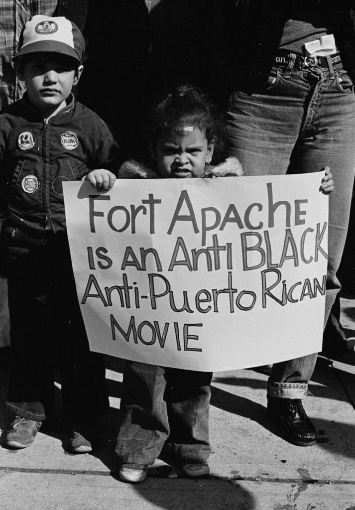Une jeune fille proteste contre le film "Fort Apache, The Bronx" dans le Bronx, organisé par le CAFA (Comité contre Fort Apache). Sur sa pancarte, on peut lire : "Fort Apache est un film anti-noir et anti-Puerto Rican". 1980 © Joe Conzo Jr.