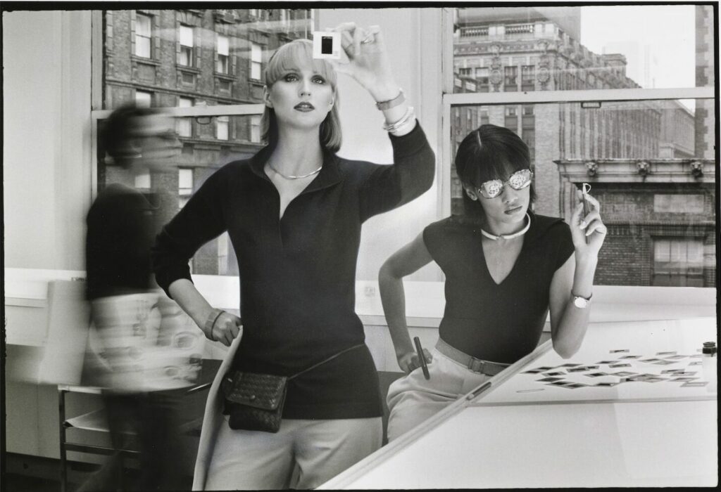 Two models in an office looking at negatives, 1976, Vogue, © Condé Nast / Duane Michals