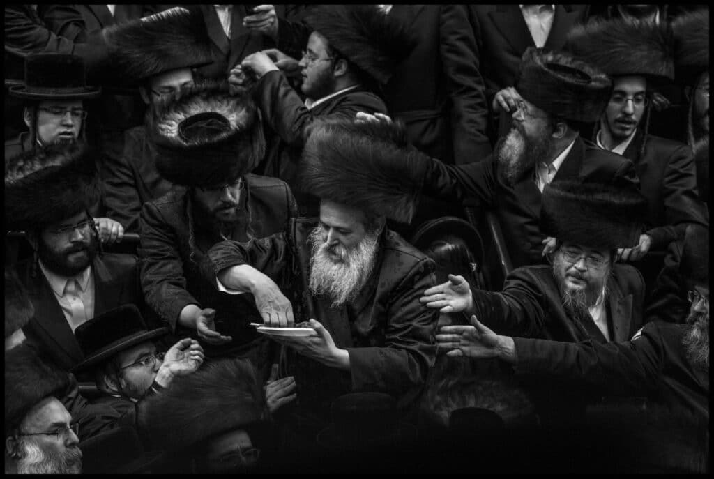 Jérusalem, Israel, 2016. La secte juive des Belz célèbre Pourim avec un tish, une part symbolique de pain et de poisson, dans une grande salle en forme de stade sous leur synagogue. Abbas © Fonds Abbas Photos/Magnum Photos