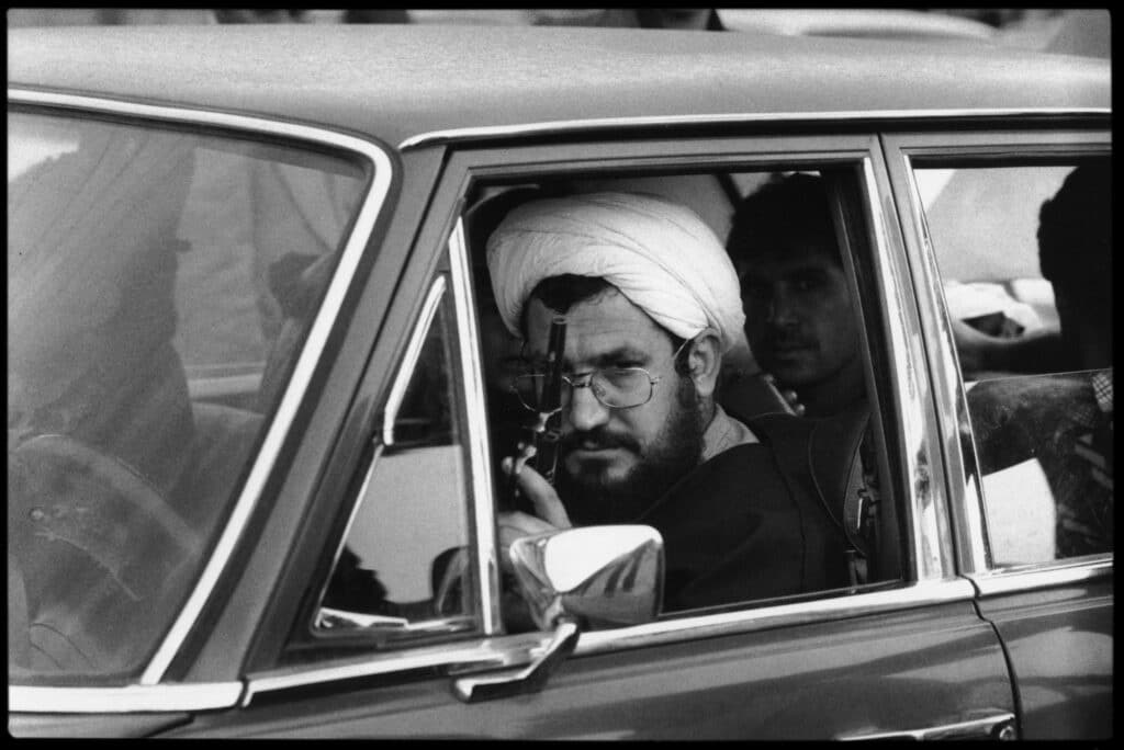 IRAN. Tehran. February 11th 1979. A mullah, sitting in a luxury car, exhibits his weapon on the day of the victory of the Revolution. Abbas © Fonds Abbas Photos/Magnum Photos