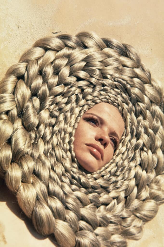 Model Veruschka with head surrounded by circles of braided gold hair in Egypt