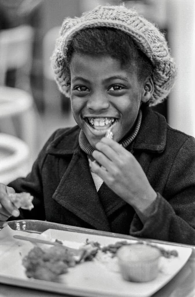 1972 - Oakland, Californie, États-Unis : le programme de petits déjeuners gratuits pour les enfants, géré par le Black Panther Party. Le programme de petits-déjeuners gratuits pour les enfants scolarisés était l'un des plus de 60 programmes gérés par le Panther Party. Parmi les autres programmes, citons les cliniques de santé gratuites, la nourriture gratuite, les vêtements et les chaussures gratuits, SAFE (escorter les personnes âgées pour qu'elles ne soient pas agressées) et l'Oakland Community School, qui offrait un enseignement de haut niveau à 150 enfants issus de quartiers urbains défavorisés. © Stephen Shames