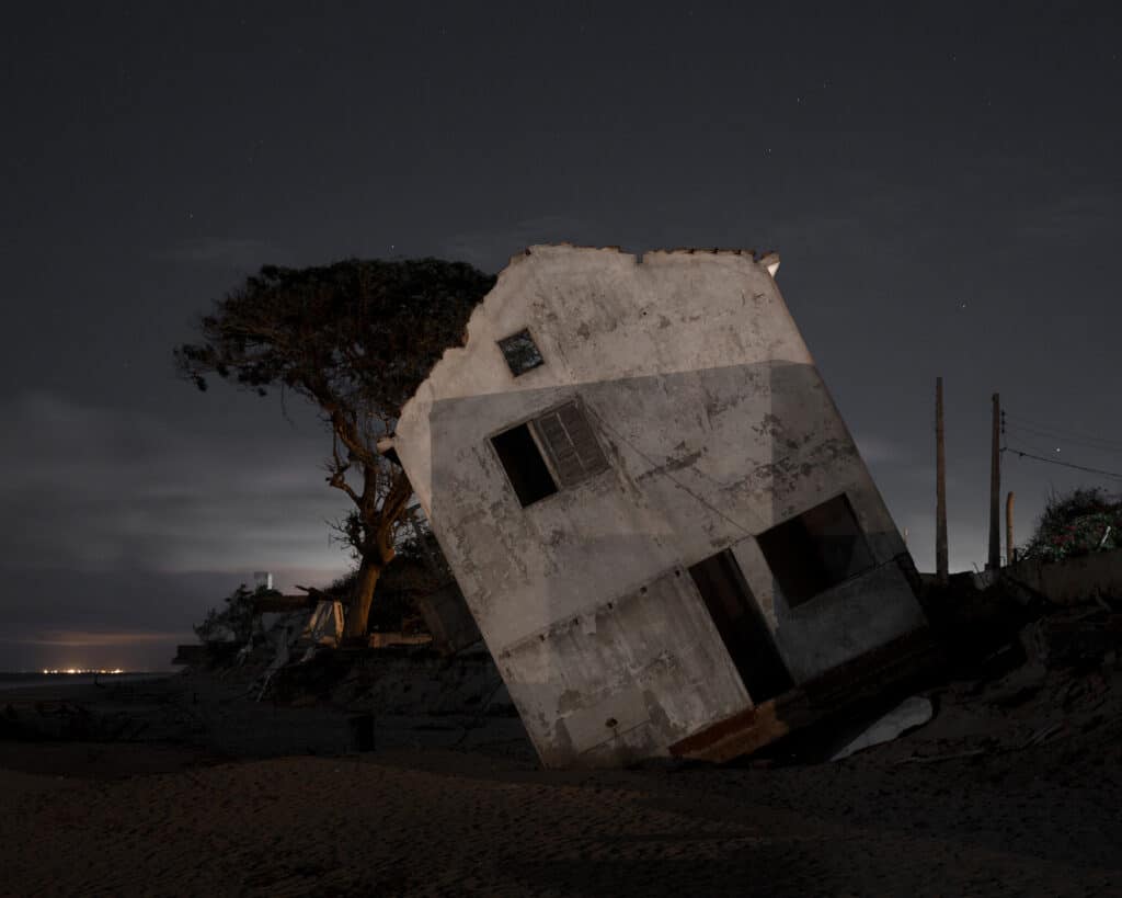 Une maison détruite sur la plage d'Atafona. Au fur et à mesure que l'eau de mer érode la plage, les bâtiments deviennent instables et finissent par basculer dans la mer. La maison a été complètement détruite en 2016. De nombreuses photographies de cette série sont des documents visuels d'un paysage qui n'existe plus tel qu'il était, confirmant les transformations rapides et inquiétantes de la société contemporaine.