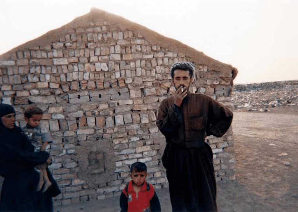 “Sadiq Mahdy (smoking) moved to Baghdad to join relatives after the first war in Iraq. He is currently jobless and shown here with his family. His daughter was named Americas the day U.S. troops entered Baghdad.” © Jassim Mohommad